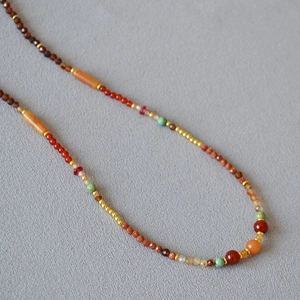 Detailed close-up of beaded necklace featuring agate, turquoise, and layered natural stones