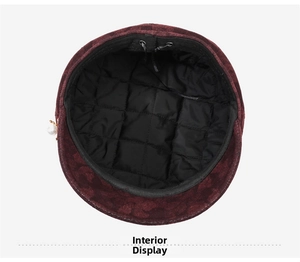 Detailed view of the black quilted lining and pearl accent on a burgundy octagonal hat
