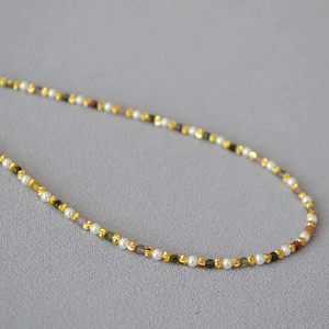 Elegant beaded necklace featuring small pearls, gold beads, and colorful gemstones