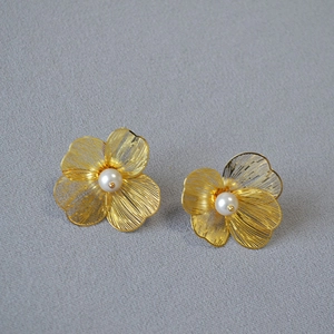Elegant gold woven hollow flower earrings with central white pearls in minimalist style