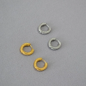 Detail of twisted rope texture and clasp on gold and silver hoop earrings