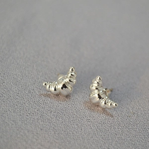 Detailed view of silver croissant stud earrings with polished metallic ripple textures