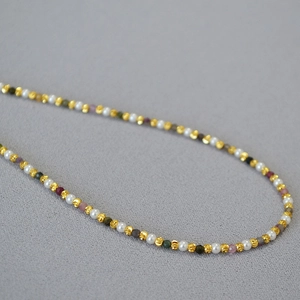 Detailed close-up of French style necklace with white pearls and colorful gemstones