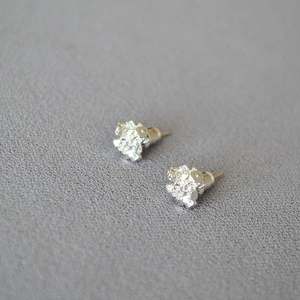 Minimalist silver irregular crystal cluster earrings with shiny metallic texture on grey background
