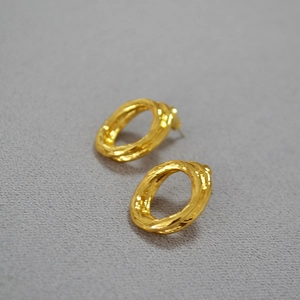 Detailed view of gold plated brass hoop earrings with irregular textured molten design