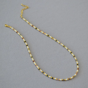 Close-up of pearl and tourmaline beaded necklace with gold chain and lobster clasp