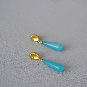 Detail of vintage brass gold drop earrings with light blue waterdrop stones and 925 silver pins