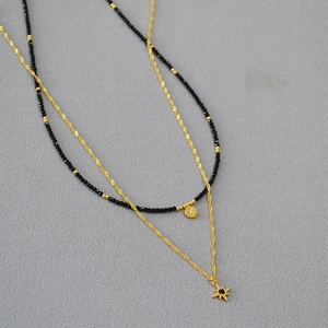 Detailed shot of double-layer necklace with black spinel beads and star-shaped pendants