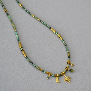 Detail of vintage turquoise beaded necklace with gold moon and star pendants