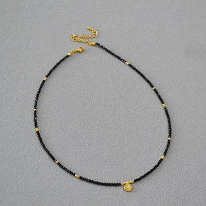 Minimalist double-layered necklace with black spinel beads and star pendant in gold finish