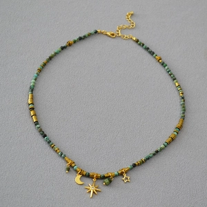 Detail view of turquoise beaded necklace with golden star moon pendants and lobster clasp