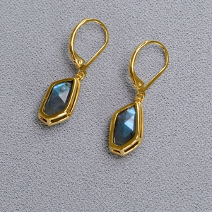 Macro shot of irregular cut labradorite earrings with gold-plated geometric frames
