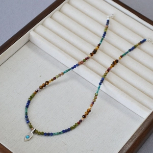 Collier bohème en perles de pierres précieuses avec pendentif turquoise sur un présentoir