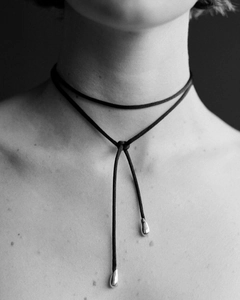 Detail of adjustable black cord choker with silver teardrop pendants and knotting