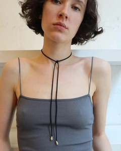 Detail of adjustable black cord choker with elegant silver water-drop pendants on model