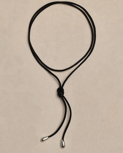 Close-up of black cord necklace with bow-tie knot and silver teardrop pendants
