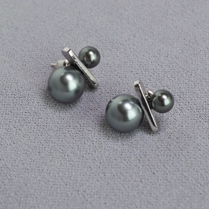 Modern double grey pearl earrings with silver metallic bars on dark textured fabric