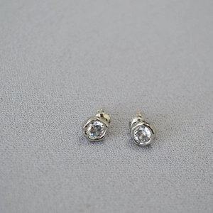 Macro detail of S925 sterling silver stud earrings with zirconia in scalloped bezel setting
