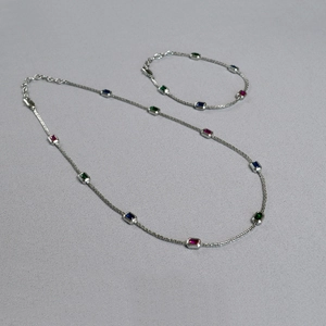 Detail of brass necklace with rectangle emerald, sapphire, and ruby gemstones