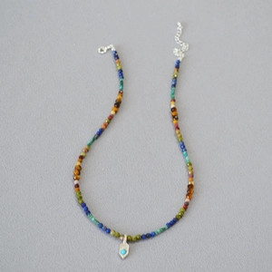 Détail du collier de perles colorées avec pendentif turquoise et fermoir mousqueton
