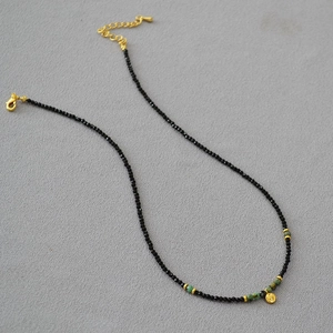 Detail der Perlenkette mit schwarzem Spinell, Türkissteinen und goldenem Herzanhänger