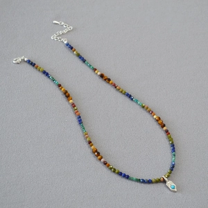 Gros plan du collier de perles bohème coloré avec pendentif turquoise et chaîne argentée réglable