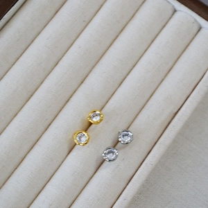 Macro shot of gold and silver plated stud earrings with sparkling round cubic zirconia
