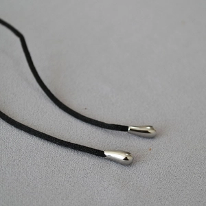 Close-up of black braided cord with silver teardrop metal ends and polished finish