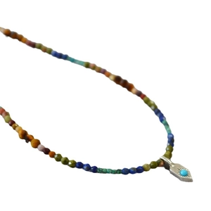 Collier de perles bohème avec pendentif soleil en turquoise sur un fond blanc pur