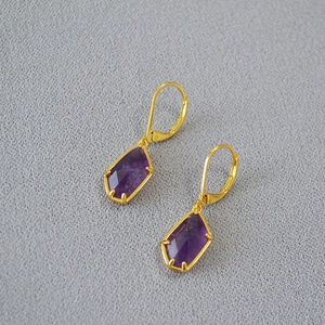 Minimalist gold lever back earrings featuring irregular faceted purple amethyst stones