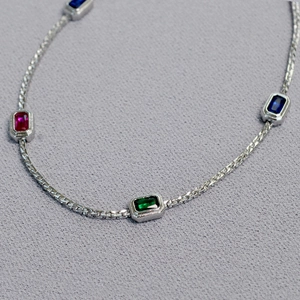 Macro view of silver brass chain necklace with colorful rectangular gemstone settings