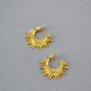 Golden sunburst earrings with a textured C-shape half-moon design in a vintage punk style