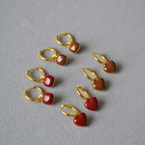 Vue détaillée des boucles d'oreilles dorées en émail rouge et marron cœur et carré