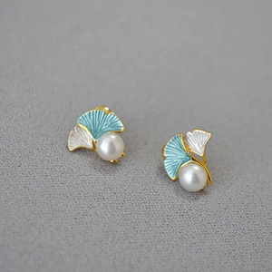 Detail of ginkgo leaf earrings with blue enamel petals and round freshwater pearls