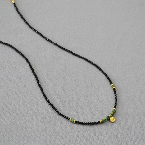 Detail der Perlenkette mit schwarzem Spinell, Türkis und goldenem Herzanhänger