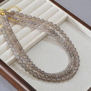 Colliers en agate gris fumé avec chaînes d'extension dorées dans un coffret à bijoux