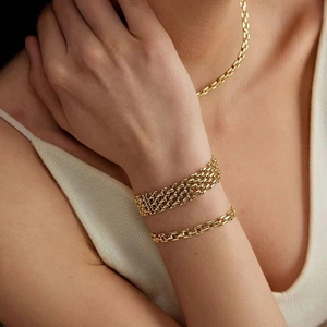 Detail of chunky gold-plated hollow chain bracelet and matching necklace set on model
