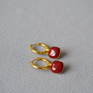 Vue détaillée des boucles d'oreilles pendantes carrées rouges avec anneaux en métal doré