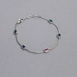 Detailed shot of brass chain necklace with colorful rectangular gemstones and lobster clasp