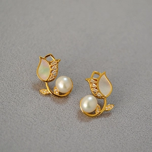 Detail view of tulip earrings with freshwater pearls and zircons on a textured base