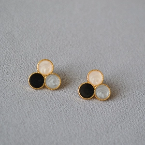 Detail of three-color enamel stud earrings with marble texture and gold metal frame