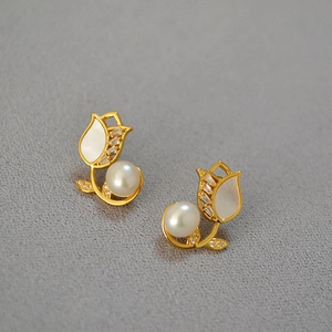 Elegant tulip flower earrings with white pearls and gold metal plating on grey surface