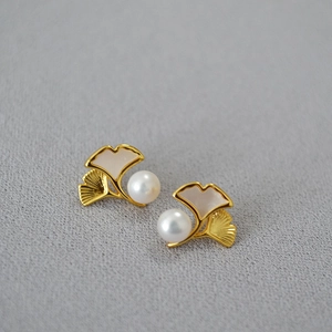 Macro shot of ginkgo leaf earrings with gold plating and fresh water pearls