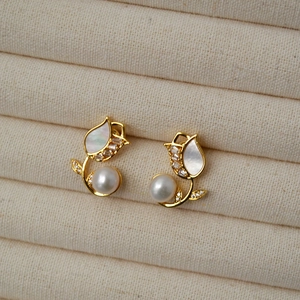 Detailed view of tulip stud earrings with freshwater pearls and mother of pearl inlay