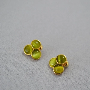 Golden cluster stud earrings with green cat-eye stones in a triangular arrangement