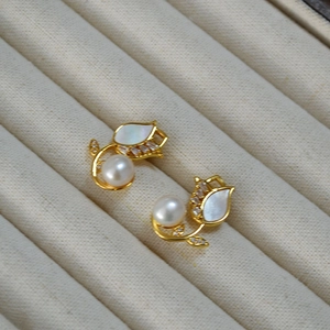 Macro shot of tulip earrings with mother-of-pearl petals and white freshwater pearls