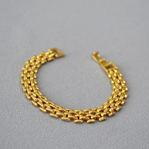 Detail view of the gold-plated chain link bracelet with polished fold-over clasp finish