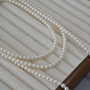 Détails de perles blanches de haute brillance sur un plateau à bijoux minimaliste