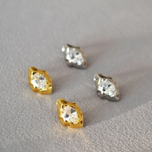 Detailed view of irregular lava style stud earrings with marquise cut zircon stones