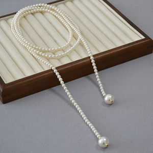 Élégant long collier de perles avec grands pendentifs dans un coffret à bijoux chic